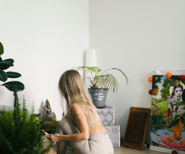 A calm and tidy space for yoga practice with a mat and some plants.